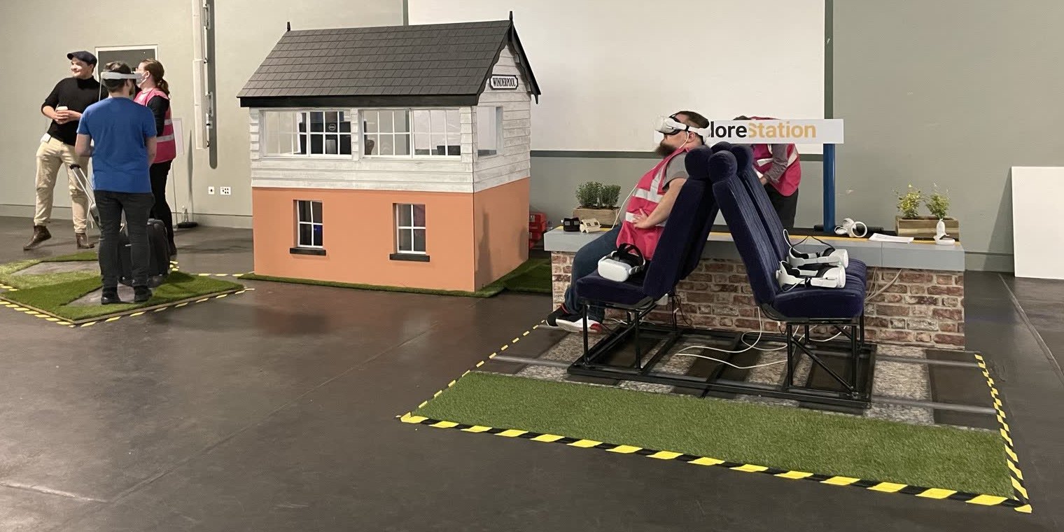 The ExploreStation set at the National Railway Museum: a signal box, train seats and a turf platform, with visitors in VR headsets