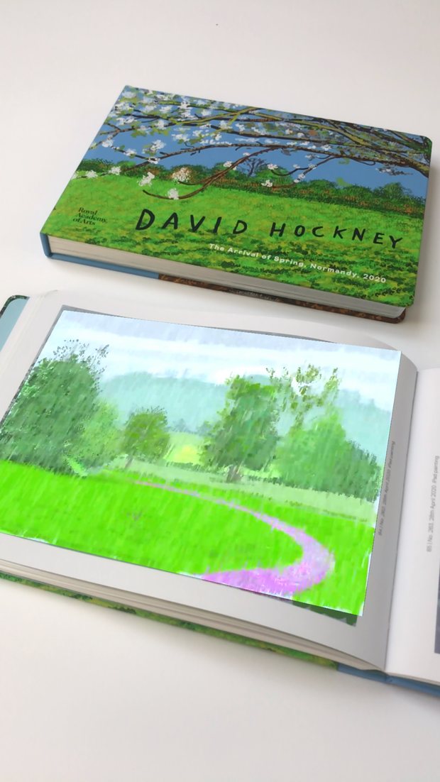 Hockney AR in use: a rain painting animating out of an open page of the Royal Academy catalogue, with the catalogue's cover behind