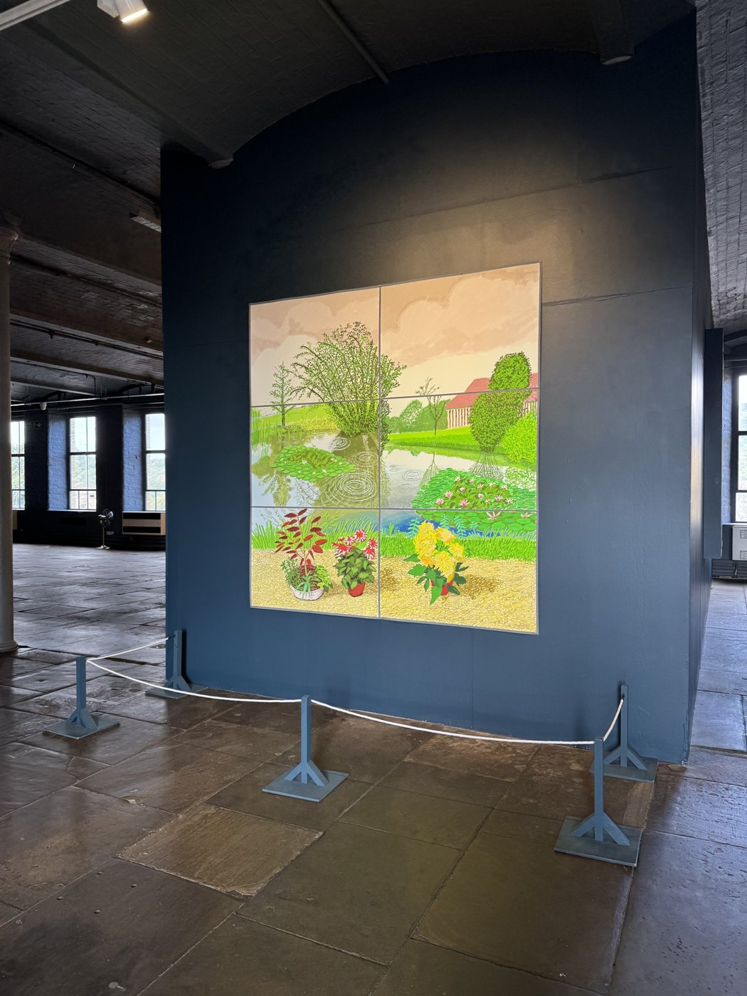 The six-screen installation at Salts Mill showing the finished water-lily painting, on a dark blue wall in the gallery