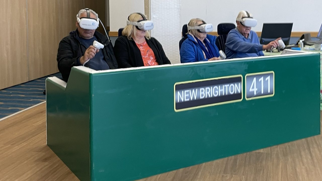 Four visitors in VR headsets on the New Brighton 411 open-top bus rig, a VR public consultation for Wirral Council